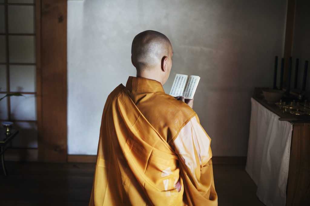 Buddhist monk in a golden robe worshipping